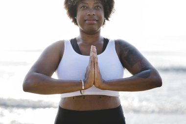 Afrikalı-Amerikalı kadın pratik yoga sahilde