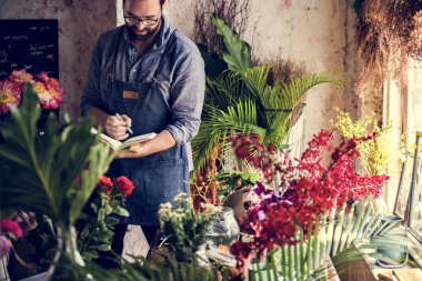 Adam bir çiçekçide not alma