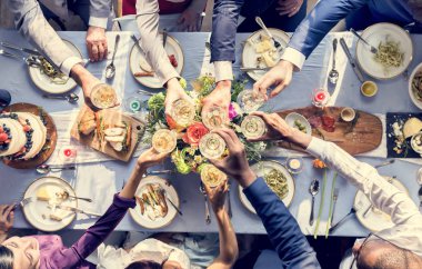 Onların şampanya bardağı kadeh kaldırmak için bir düğün masada tutan insanlar