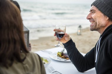 Sahilde kırmızı şarap ile toasting yaşlılar