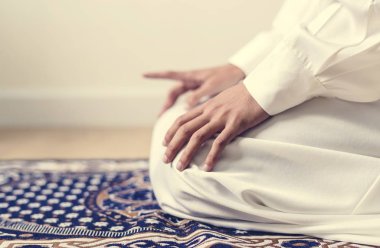 Teşehhüt Müslüman dua duruş, halıya elleriyle dizlerinin üzerinde oturan kişi kırpılmış görüntü