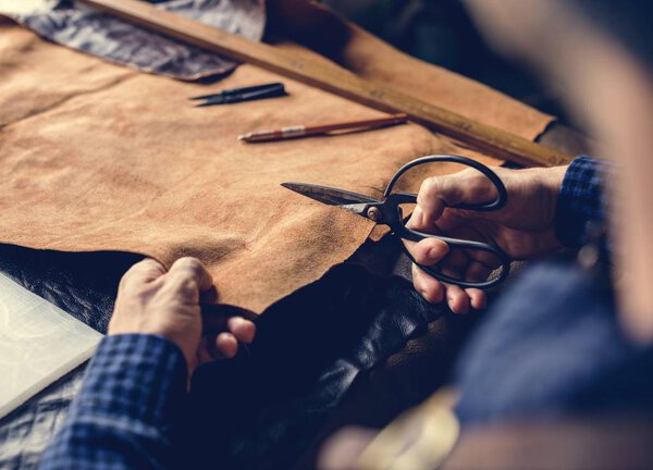 Craftsman cutting into a hide