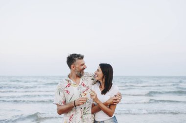 Kumsalda şarap içen çift.