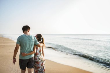 Kumsalda yürüyen çift.