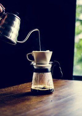 Barista damlayan kahve yapıyor.