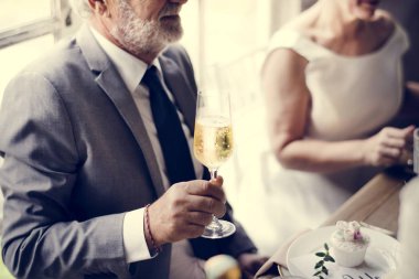 Şampanya şarap bardağını tutan kıdemli gelin el