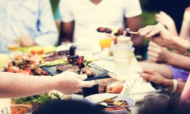 Bir grup insan açık havada barbekü partisi