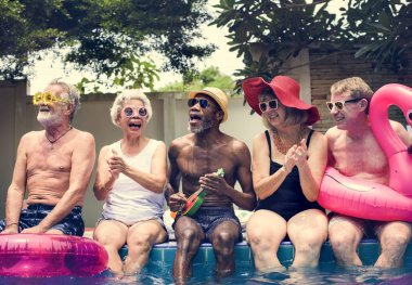 Grup birlikte yaz keyfi havuz kenarında oturan farklı kıdemli yetişkin