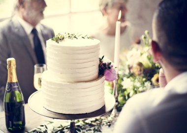 Şampanya şişesi ile beyaz düğün pastası