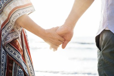 Olgun çift sahilde elele