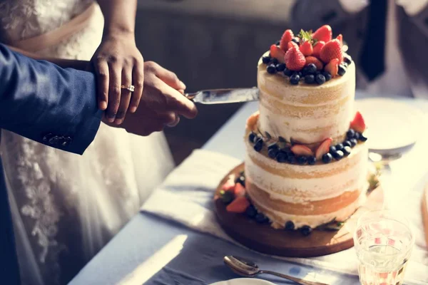 結婚式のケーキを切るカップル手 — ストック写真