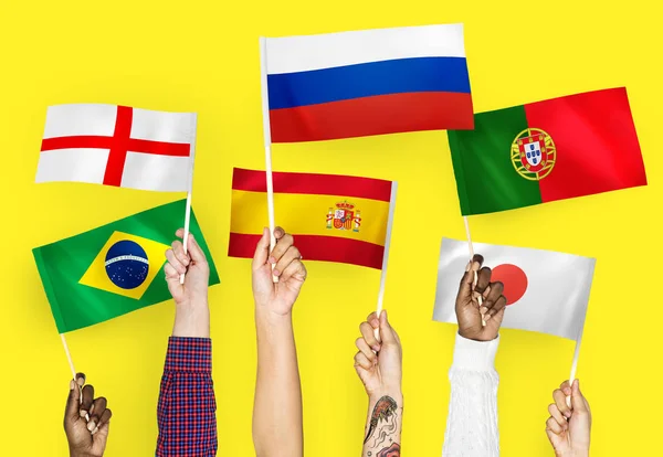 Hands Raising National Flags England Spain Japan Portugal Russia Brazil — Stock Photo, Image