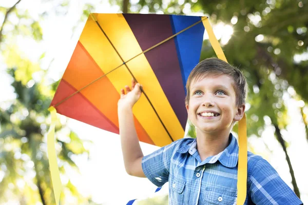 Chico Sonriendo Jugando Con Una Cometa Colorida —  Fotos de Stock