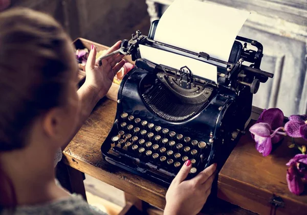 Woman typing typewriter on the table