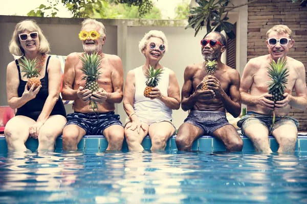 Skupina Rozmanitých Starší Dospělé Posezení Bazénu Stmelování Ananas — Stock fotografie