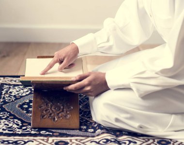 Müslüman erkek Kur'an, okuduktan kırpılmış görüntü kitapta dua işaret parmağı 