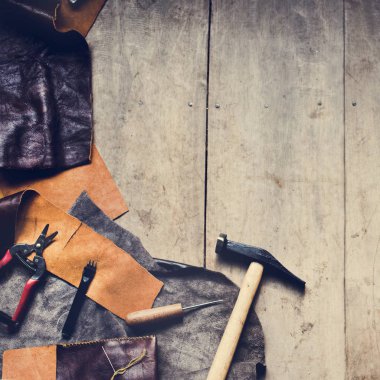 Ahşap masa üstünde alet ile deri işçiliği, havadan görünümü