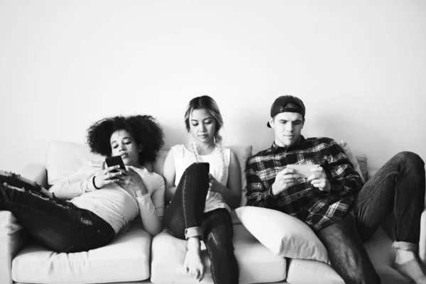 在沙发上使用手机的朋友们 — 图库照片