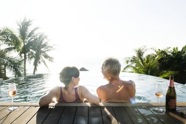 Üst düzey çift bir yüzme havuzunda prosecco içme