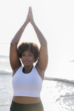 Afrikalı-Amerikalı kadın pratik yoga sahilde