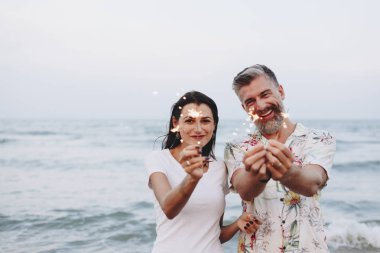 Çift sahilde havai fişekleri ile kutluyor