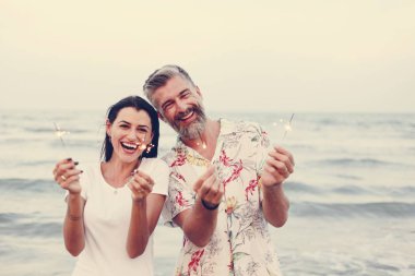 Çift sahilde havai fişekleri ile kutluyor