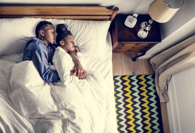 Güzel Afrikalı-Amerikalı çift yatakta snuggling
