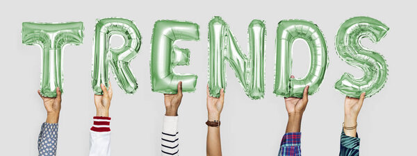 Green alphabet helium balloons forming the text trends