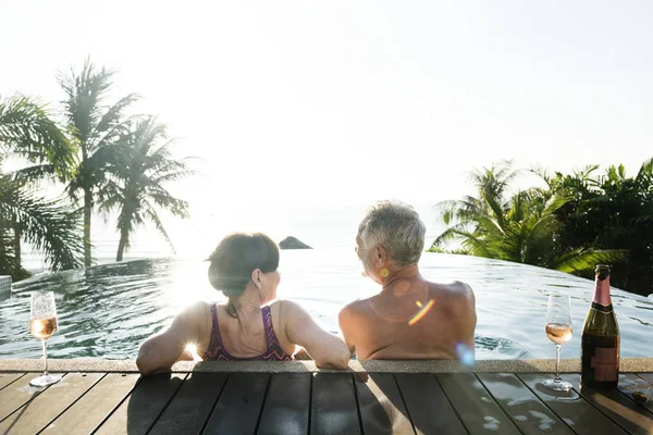 Üst düzey çift bir yüzme havuzunda prosecco içme