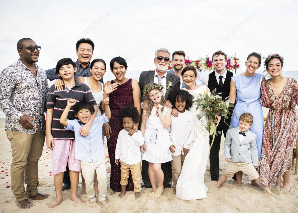 large group of multiethnic friends and family at beach during wedding