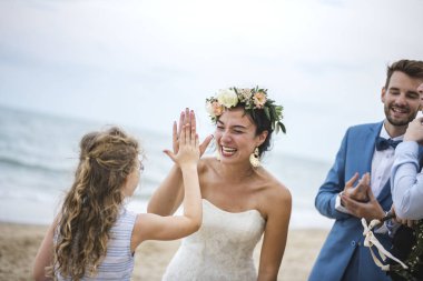 Beach düğün töreni sırasında küçük kıza çak bir beşlik veren genç mutlu gelin