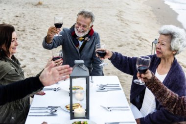 Sahilde kırmızı şarap ile toasting yaşlılar