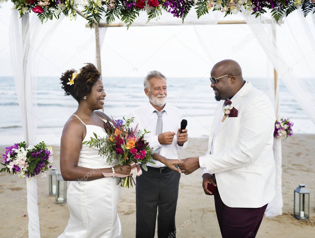 African American couple getting married at beach wedding
