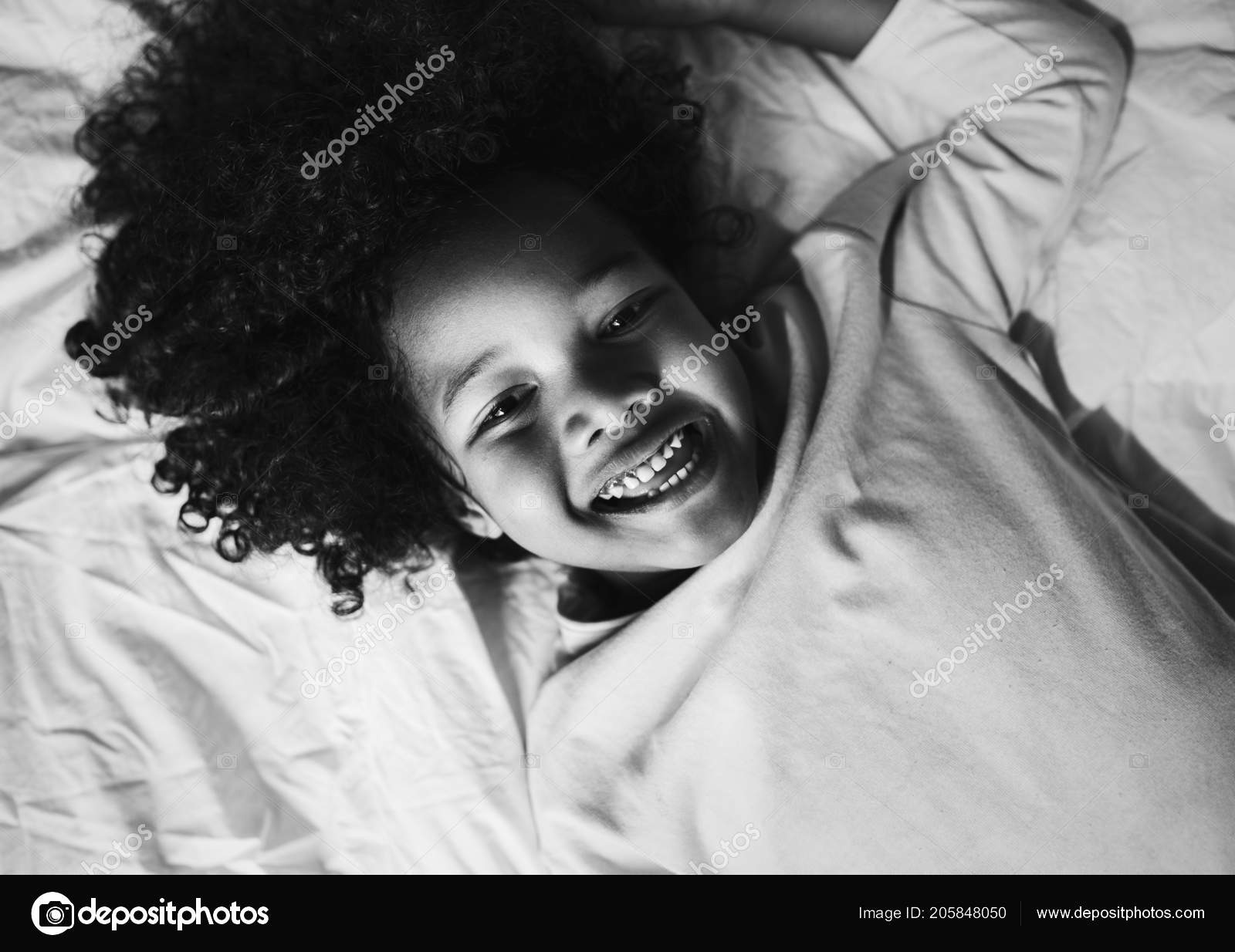 African child enjoying smiling bed stock photo