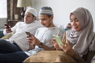 Muslim friends using social media on phones clipart