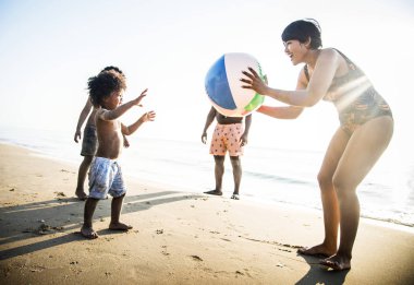 Kumsalda topla birlikte oynamayı mutlu Interracial aile