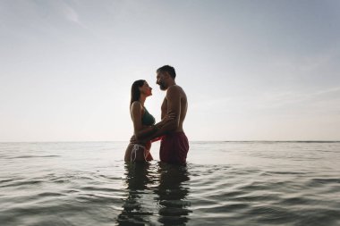 Gün batımında denizde romantik bir çift