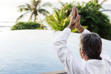 Havuzun yanında Yoga uygulamak kıdemli yetişkin