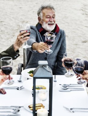 Sahilde kırmızı şarap ile toasting yaşlılar