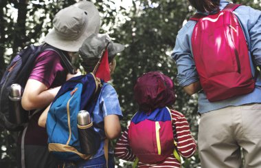 Arkadan Görünüş aile yürüyüşçü üzerinde uzak ormanda seyir sırt çantaları ile