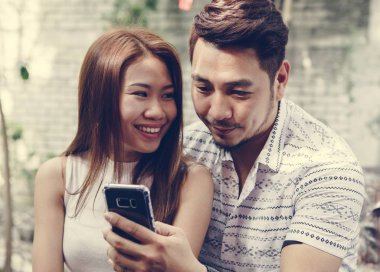 Genç çift birlikte bir telefon kullanma