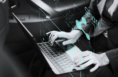 Bir arabada bir dizüstü bilgisayar üzerinde çalışan iş kadını