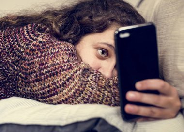 Bir yatak sosyal medya ve bağımlılık kavramı üzerinde bir akıllı telefon kullanan genç kız