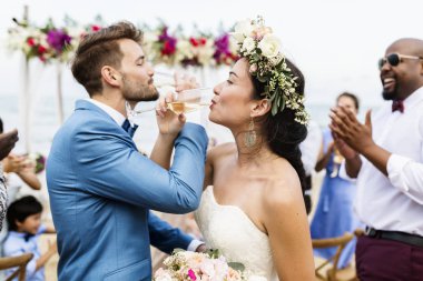 Aşk yapıyor neşeli yeni evliler şampanya ile plaj düğün töreninde vurdu.