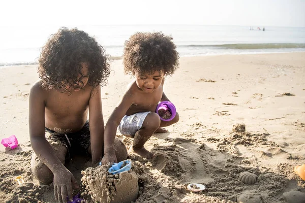 可爱的小非洲裔美国孩子在沙滩上建造沙子城堡 — 图库照片