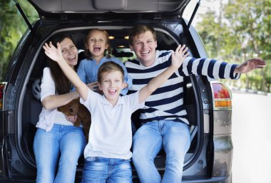 Ebeveynler ve çocuklar aile arabası araba bagajında oturan, Aile bir yolculuğa çıkıyor