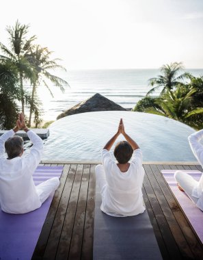 Grup üst düzey arkadaşlar Yoga havuzun yanında