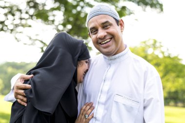 Muslim married couple in the park clipart