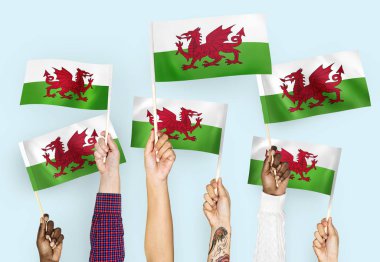 Hands waving flags of Wales clipart