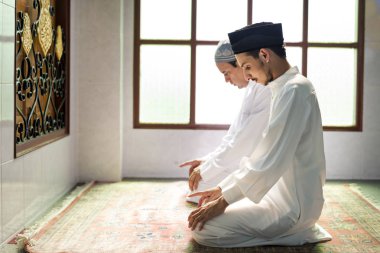 Müslüman erkekler Tashahhud duruşunda namaz kılıyorlar